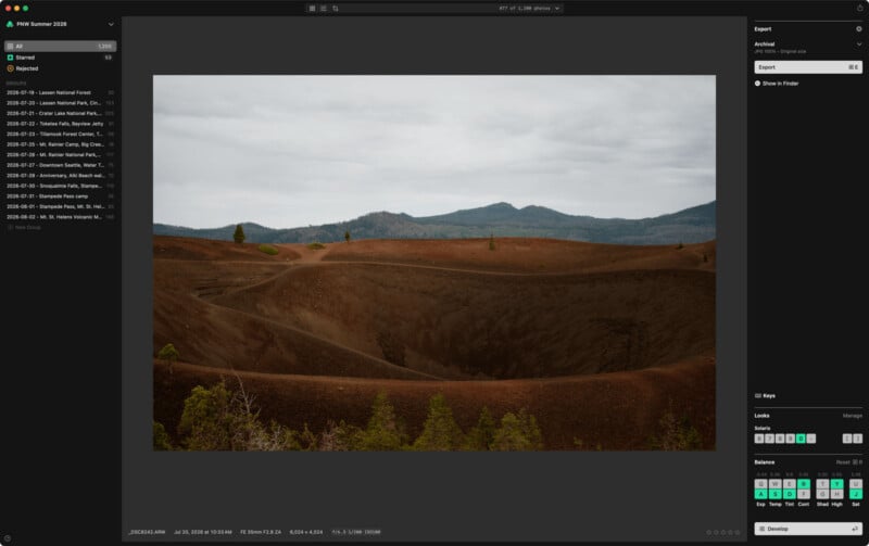 A landscape view of a volcanic crater with reddish-brown soil, sparse green trees, and distant mountains under a cloudy sky, displayed within a photo editing software interface.