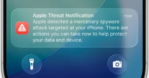 A smartphone screen displays an Apple Threat Notification warning of a mercenary spyware attack on the device.