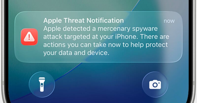 A smartphone screen displays an Apple Threat Notification warning of a mercenary spyware attack on the device.