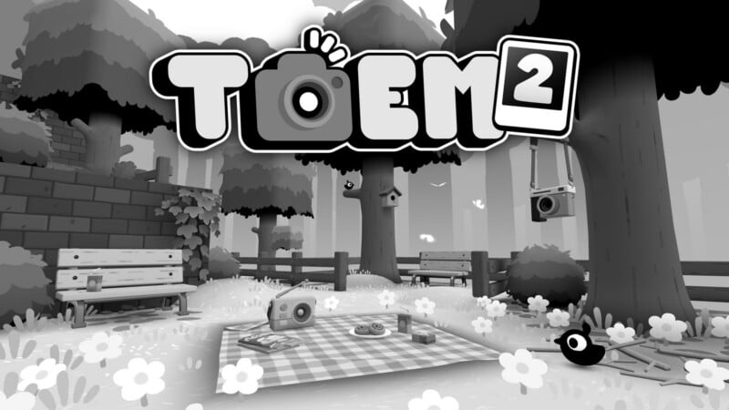 The title TOEM 2 is displayed above a black-and-white park scene featuring a picnic blanket, a radio, and a camera hanging from a tree.