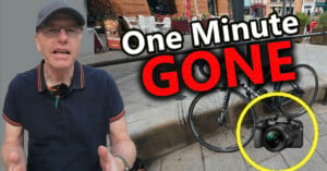 A man in a flat cap and polo shirt gestures in front of a bicycle, with the text "One Minute GONE" overlaid and a camera highlighted in a yellow circle.