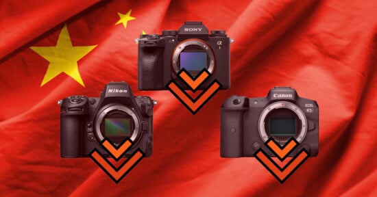 Three digital cameras are arranged in a triangle over a red flag with yellow stars, each featuring a downward-pointing orange chevron.