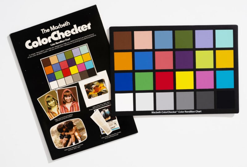A Macbeth ColorChecker chart lies partially overlapping its original black cardboard packaging, which features sample photographs and descriptive text.