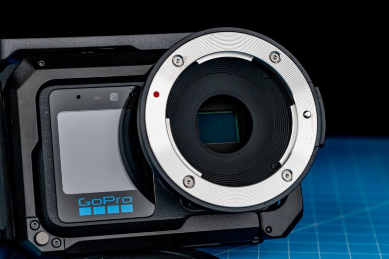 A close-up view of a GoPro camera mounted inside a protective housing with a large, circular lens mount adapter attached to the front.