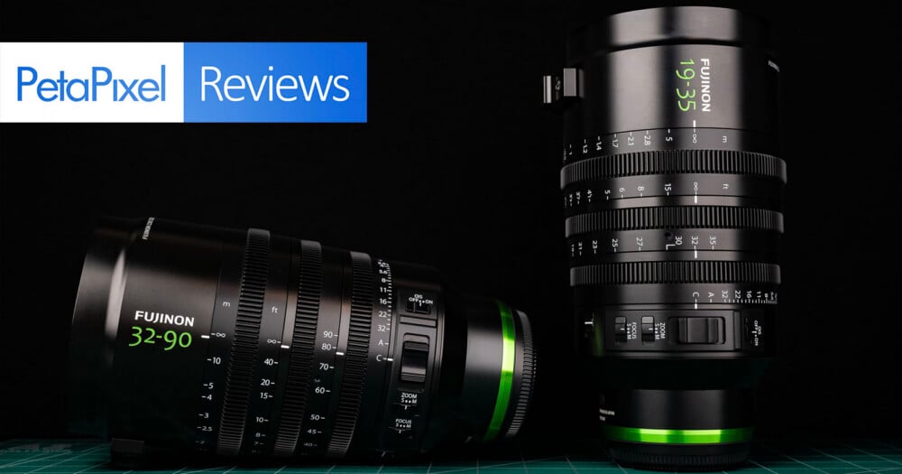 Two Fujinon cinema zoom lenses, one lying horizontally and one standing vertically, are displayed against a black background with a PetaPixel Reviews logo in the top left.