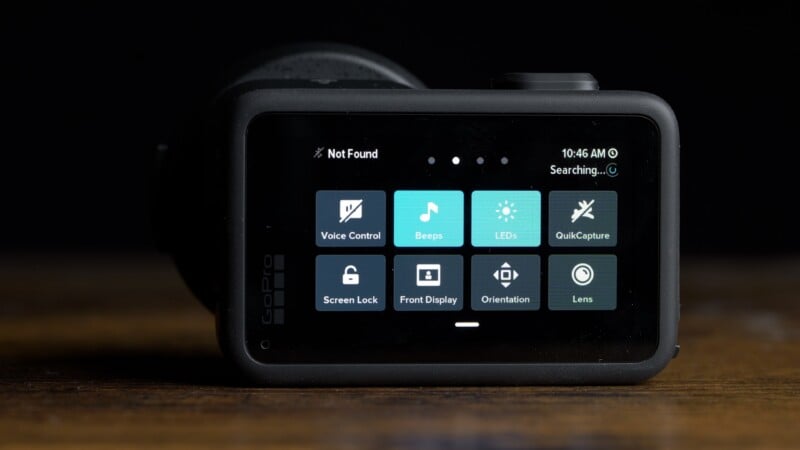A GoPro camera screen displays a settings menu with icons for Voice Control, Beeps, LEDs, QuikCapture, Screen Lock, Front Display, Orientation, and Lens.