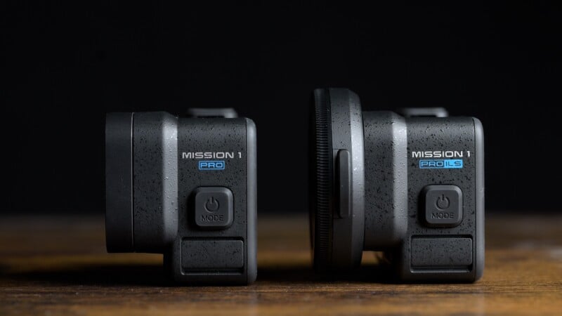 Two black action cameras sit side-by-side on a wooden surface against a dark background, with the left labeled "MISSION 1 PRO" and the right labeled "MISSION 1 PRO LS".