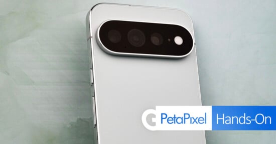 A close-up view of the back of a white smartphone featuring a horizontal, pill-shaped camera module with three lenses and a flash, with a PetaPixel Hands-On logo in the bottom right corner.