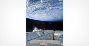 A view from the International Space Station looking down at a large, swirling hurricane over Earth's atmosphere.