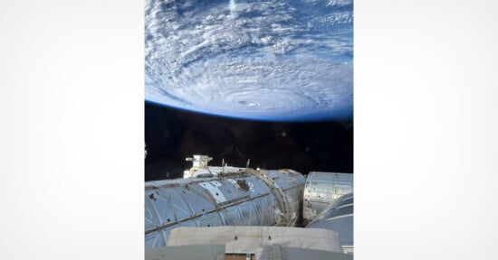 A view from the International Space Station looking down at a large, swirling hurricane over Earth's atmosphere.