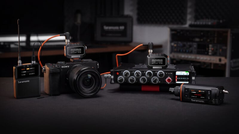 A professional audio setup featuring Saramonic timecode generators, a Sony camera, and a multi-channel field recorder on a table.