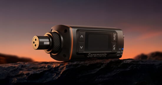 A Saramonic XLR transmitter sits on a dark, rocky surface against a sunset sky.