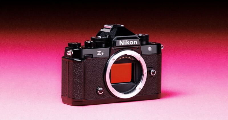 A black Nikon Zf mirrorless camera body sits centered against a gradient background transitioning from dark red at the top to bright pink at the bottom.