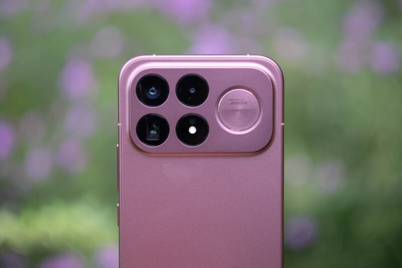 A close-up of the back of a rose-gold smartphone featuring a square camera module with three lenses, a flash, and a circular speaker grille labeled "Sound by Bose.