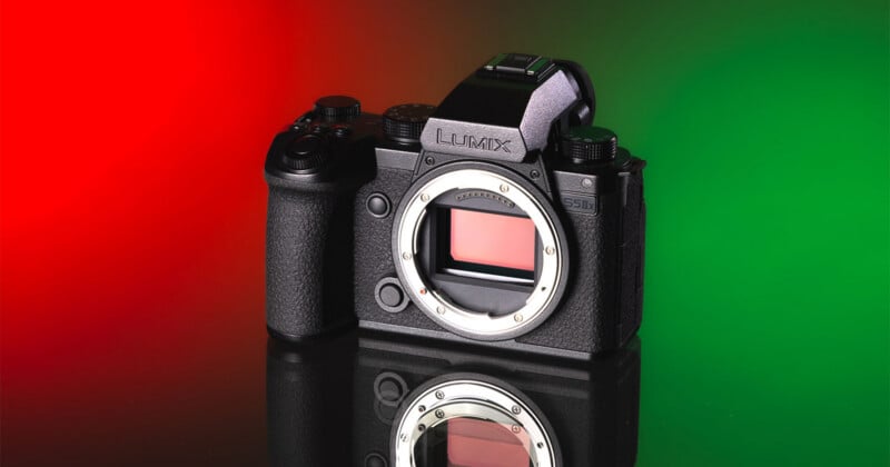 A black Lumix S5IIx camera body sits on a reflective surface against a split red and green background.