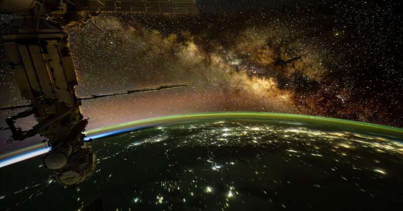 The International Space Station orbits above Earth at night, with city lights visible below and the Milky Way galaxy above.