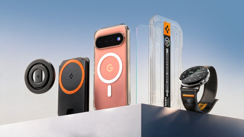 A collection of tech accessories including a magnetic charger, a card wallet, a phone in a clear case, a screen protector installation kit, and a smartwatch, all arranged on a white platform against a blue sky.