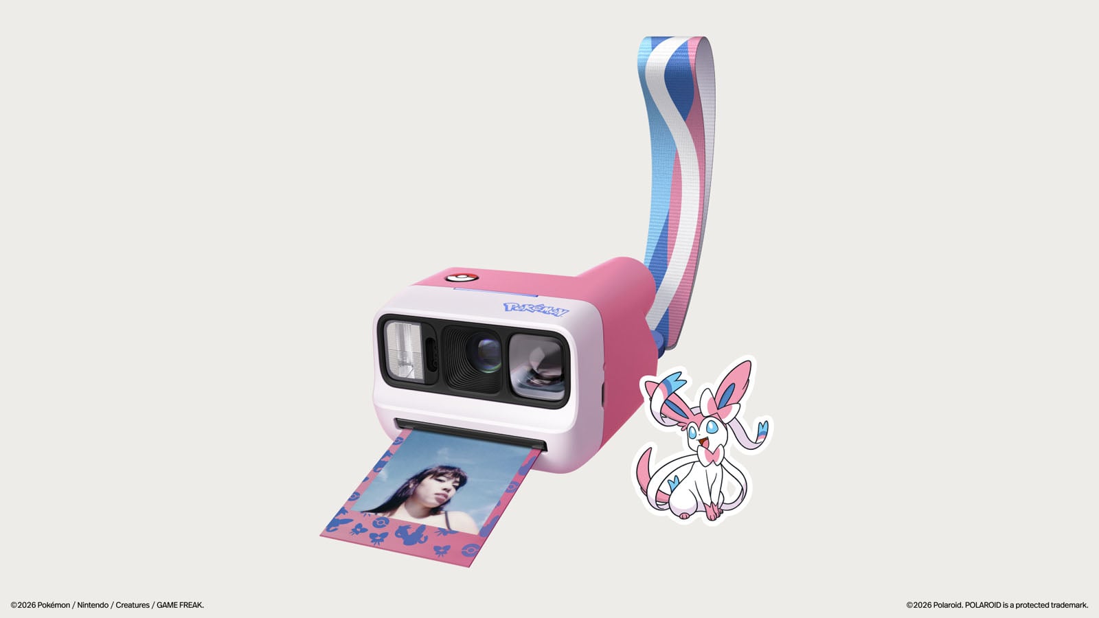 Розово-белая камера Polaroid Go в стиле Сильвеон с фирменным ремешком