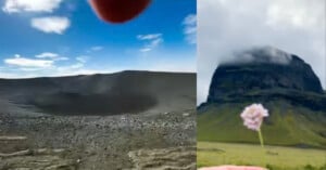 A split-screen view shows a barren, dark volcanic crater on the left and a green, cloud-capped mountain behind a small pink flower on the right.