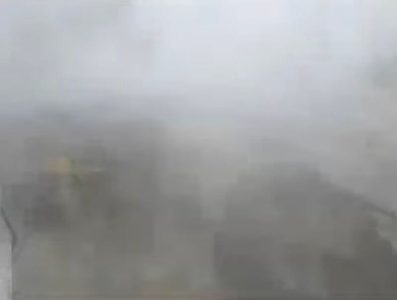 A view from a high vantage point looking down at buildings partially obscured by thick, heavy fog.