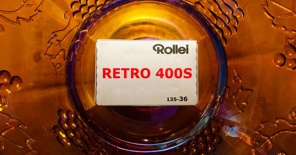 A box of Rollei Retro 400S 135-36 film sits centered on a decorative amber-colored glass plate.