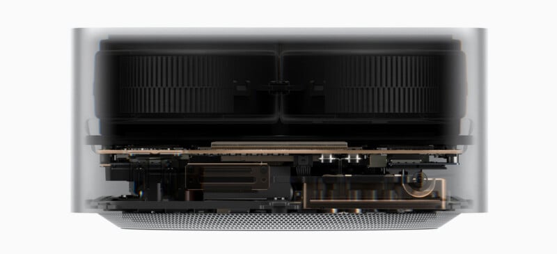 A cross-section view of a computer showing internal cooling fans, a circuit board, and metal heat sinks inside a cylindrical housing.