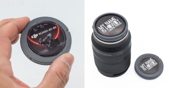 A hand holds a gray camera body cap with a DJI Ronin 4D-8K sticker, next to a camera lens with a custom "MY NAME IS HOWDY I MAKE VIDEOS" cap.
