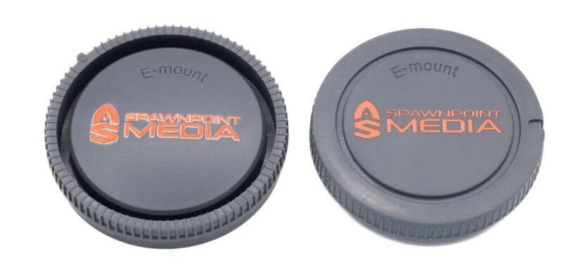 Two gray Sony E-mount camera body caps with orange "Spawnpoint Media" branding, shown from the front and back.