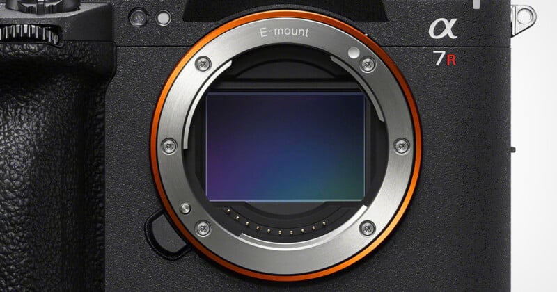 A close-up view of a camera lens mount with a visible sensor, featuring the text "E-mount" and "α 7R" on the camera body.