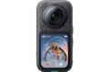 A black 360-degree action camera with a large front-facing lens and a touchscreen display showing a 360-degree photo of two people inside a bubble.