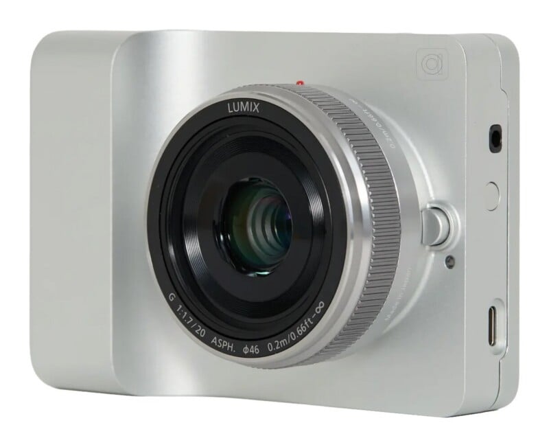 A silver, minimalist digital camera with a Lumix G 1:1.7/20 ASPH lens attached, shown from a front-side angle.