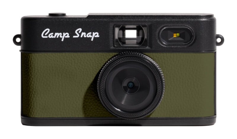 A front-facing digital camera with a black body, olive green textured grip, and the text "Camp Snap" in white script.