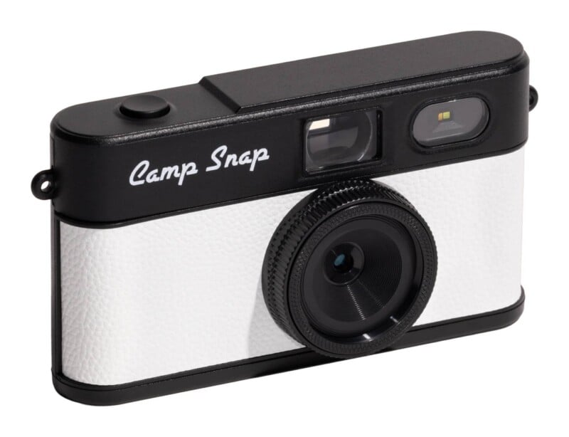 A digital camera with a black top and white textured body, featuring the text "Camp Snap" on the front.