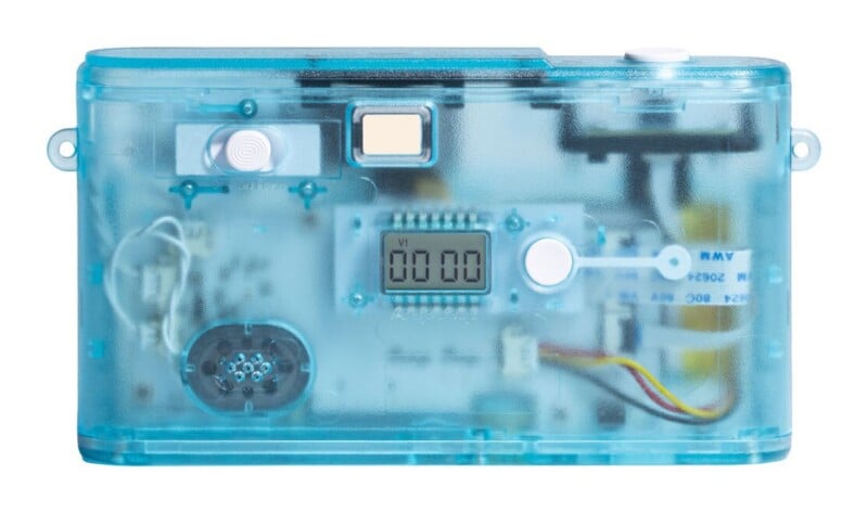 A translucent blue digital camera with a visible internal circuit board, a small LCD screen displaying "00 00", and a white shutter button.
