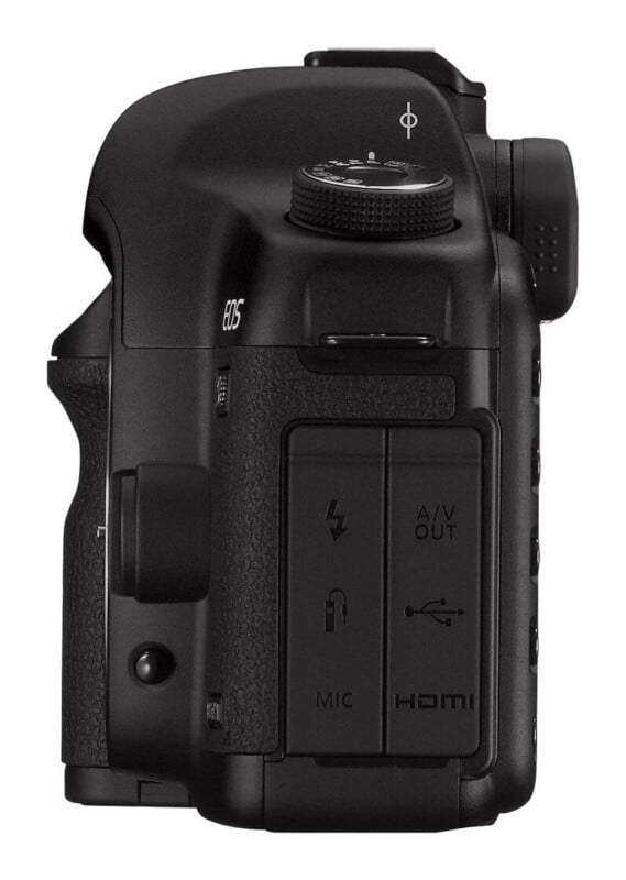 Side view of a black digital camera body showing the rubber port covers labeled with icons for microphone, remote, A/V out, USB, and HDMI.