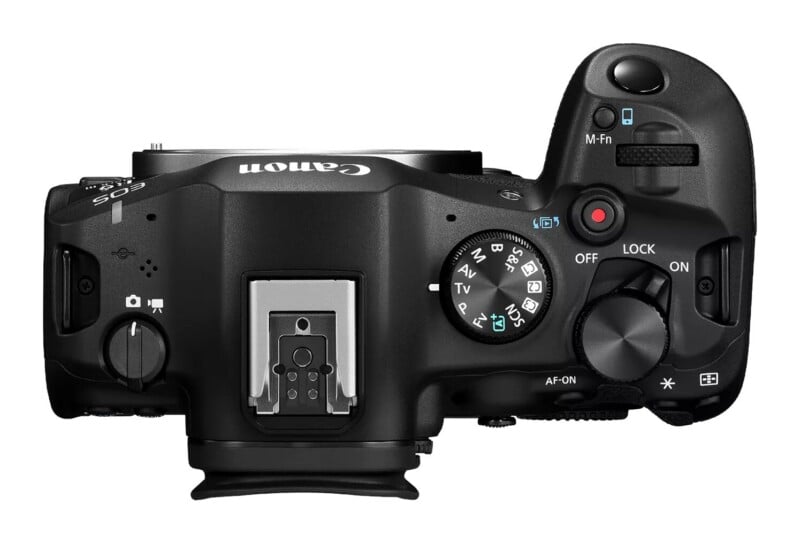 Top-down view of a black digital camera body showing the mode dial, shutter button, power switch, and hot shoe mount.