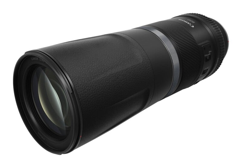A black Canon 800mm telephoto camera lens viewed from a high angle against a white background.