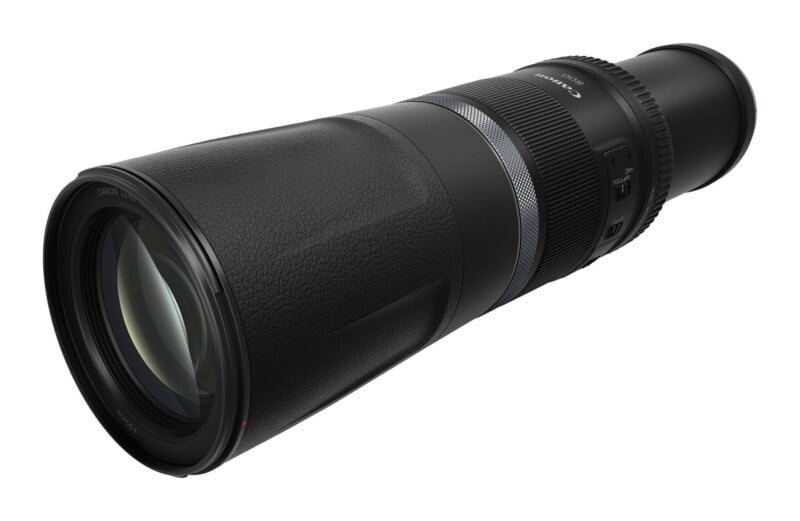 A black Canon 800mm telephoto lens shown at an angle against a white background.