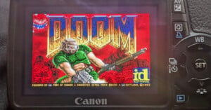 The screen of a Canon digital camera displays the title screen of the 1993 video game Doom.