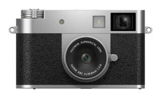 A silver and black digital camera with a fixed lens, viewed from the front, featuring text on the lens that reads "FUJINON ASPHERICAL LENS SUPER EBC f=10.8mm 1:2.8".