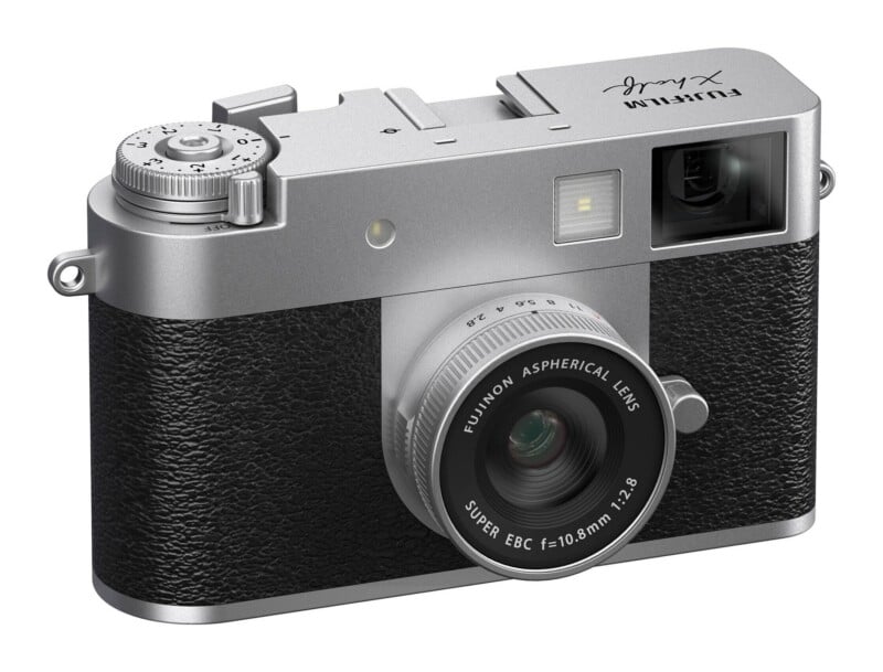 A silver and black digital camera with a fixed lens, featuring a top-mounted exposure compensation dial and a Fujinon 10.8mm f/2.8 lens.