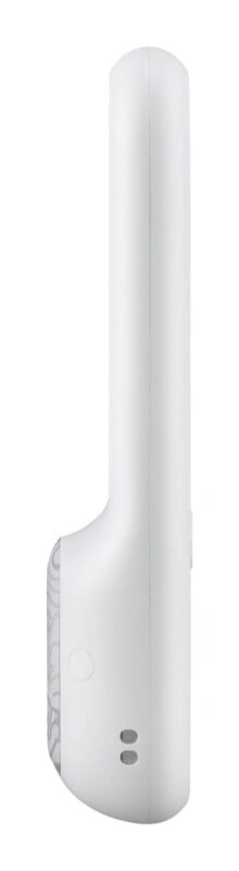 A side profile view of a white, handheld electronic device with a curved handle and a textured, patterned section near the base.
