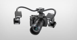 A digital camera with a macro lens is mounted with a dual-arm lighting system featuring two Godox MF-R76-style flash units.