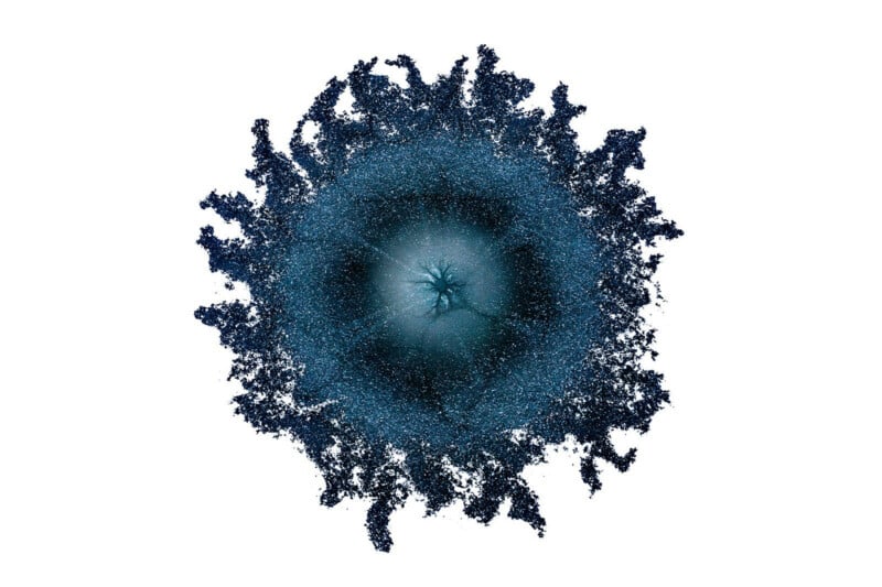 A circular, dark blue textured shape with a lighter, star-shaped center and irregular, frayed edges against a white background.