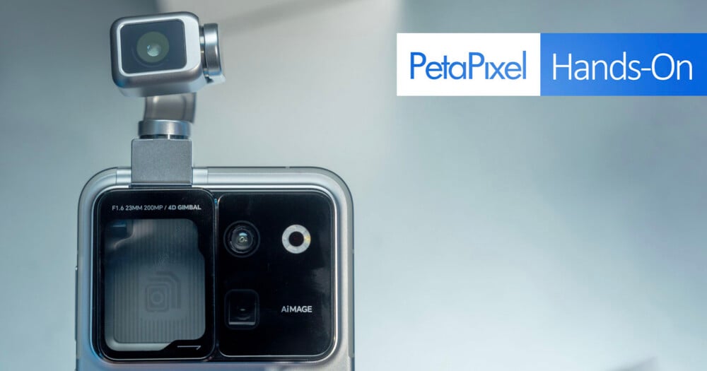 A close-up of a smartphone camera module featuring a motorized gimbal-mounted lens, with text reading "F1.6 23MM 200MP / 4D GIMBAL" and "AiMAGE," next to a PetaPixel Hands-On logo.