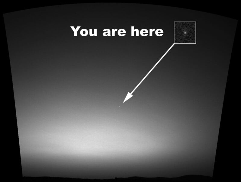 A black-and-white view of a horizon under a twilight sky, with an arrow pointing to a small, bright dot labeled "You are here" with an inset magnification.