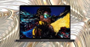 A laptop screen displays a portrait of a person with glittery makeup and bright green sunglasses against a metallic, liquid-like background.