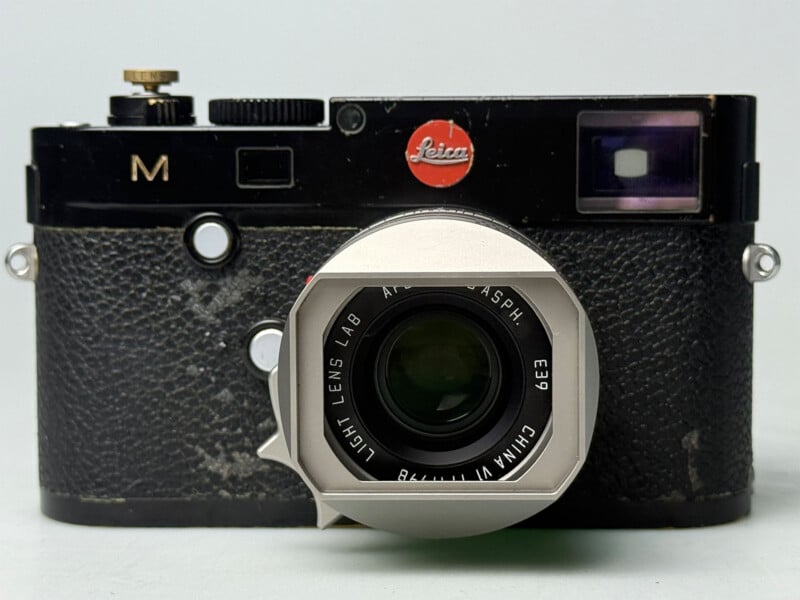 A black Leica M-series rangefinder camera with a silver lens hood attached to a lens labeled "Light Lens Lab" and "China.