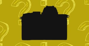 A black silhouette of a mirrorless camera centered against a mustard yellow background patterned with white line-art question marks and cubes.