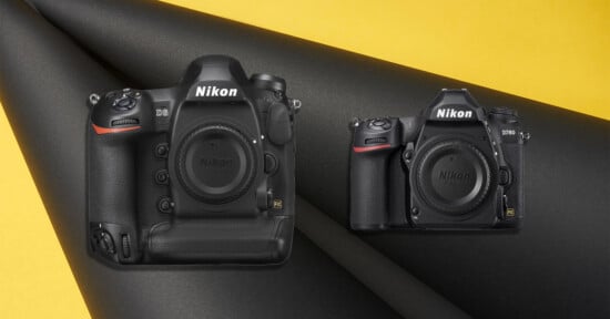 Two black Nikon DSLR cameras, a D6 and a D780, are positioned on a curved black surface against a yellow background.